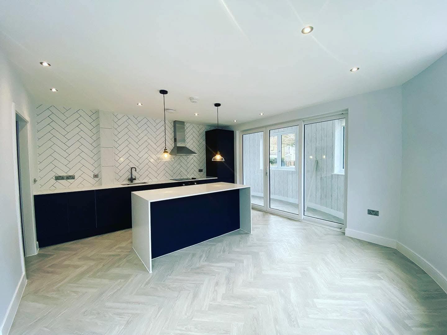 Modern kitchen with sprayed navy units by Fresh Homes